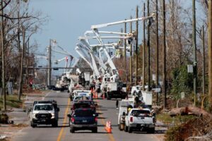 Picture of multiple utility trucks repairing dangerous down lines. 